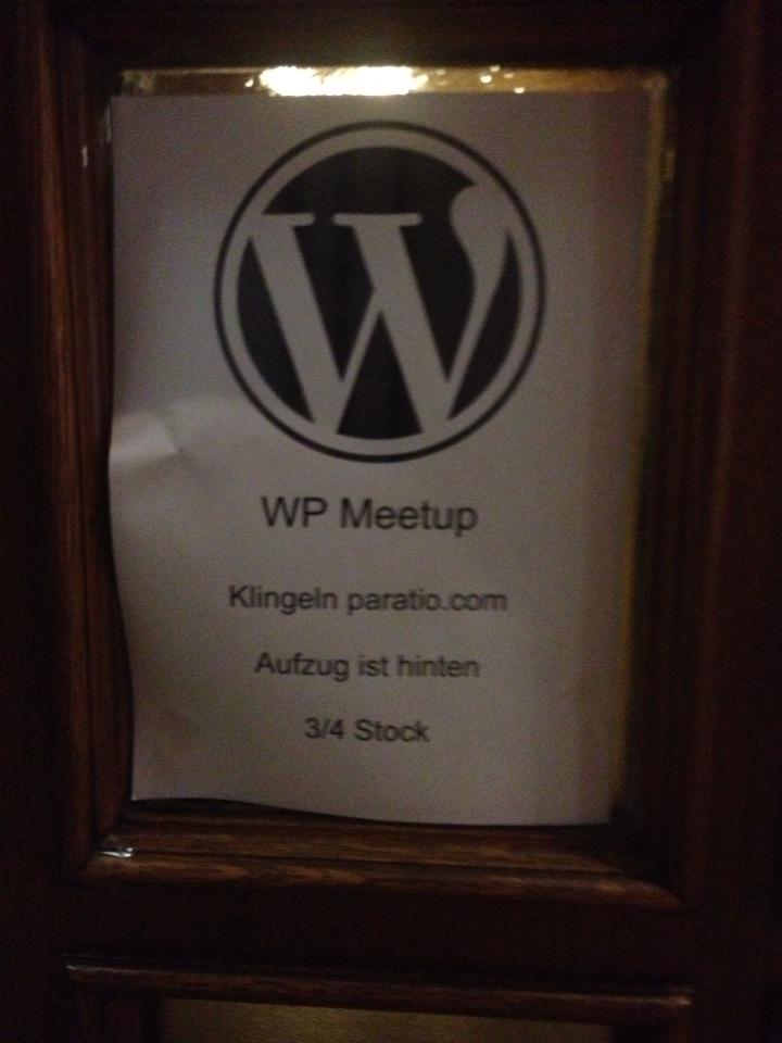 Ein Plakat mit dem WordPress-Logo und Informationen zu einem WP Meetup in einer Glasvitrine.