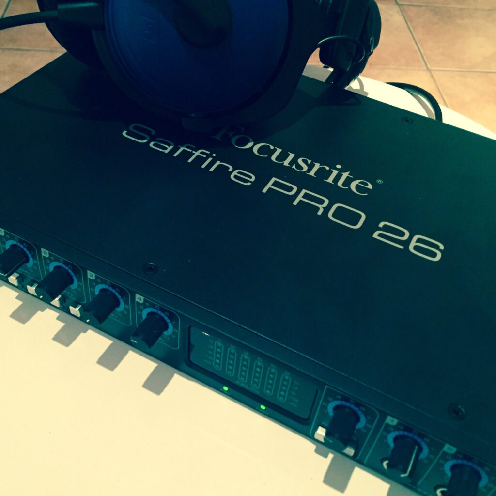 Focusrite Saffire PRO 26 Audiointerface mit angeschlossenen Kopfhörern auf einer hellen Fliese.