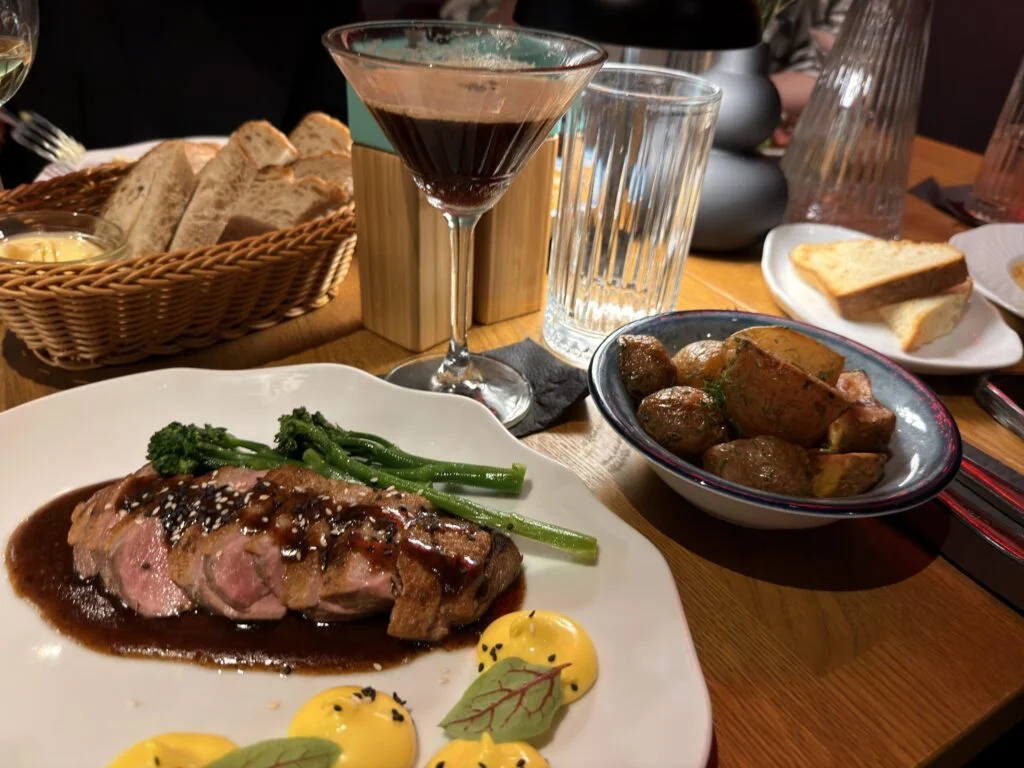 Foto eines Esstischs mit verschiedenen Tellern und Schalen und einem Espresso-Martini-Glas.