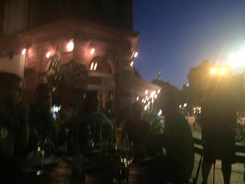 Hazy image of a group of people sitting in front of a building.