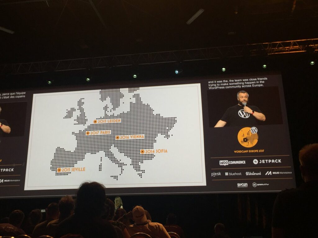 A man on stage of WCEU. A Europe map on the left