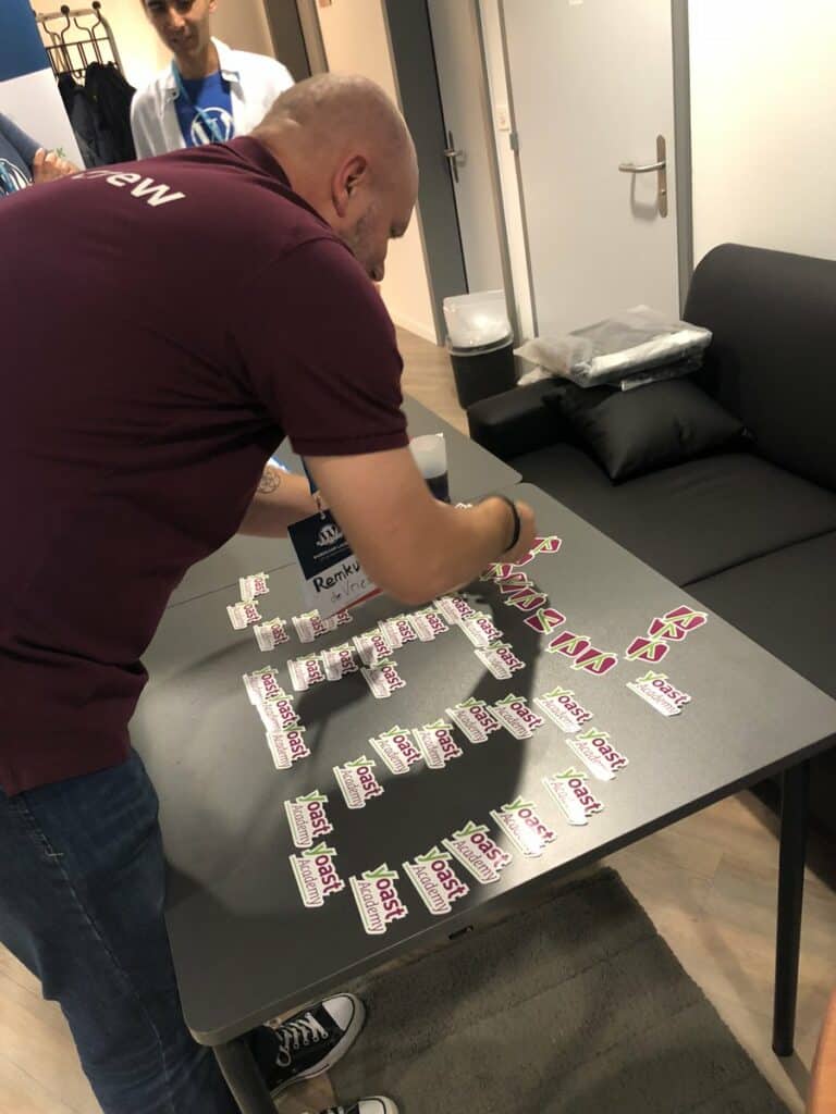 A man arranges Yoast stickers on a desk