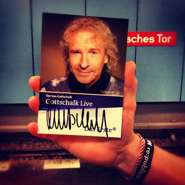 A hand holding a autographed photo of Thomas Gottschalk