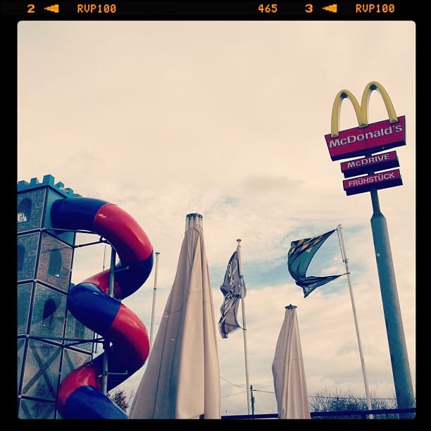 Outside a McDonalds. Tall sign next to a slide