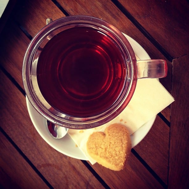 A cup of tea with a heart shaped cookie