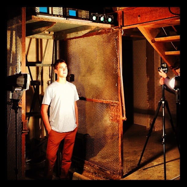 A man standing in an old rusty industrial elevator