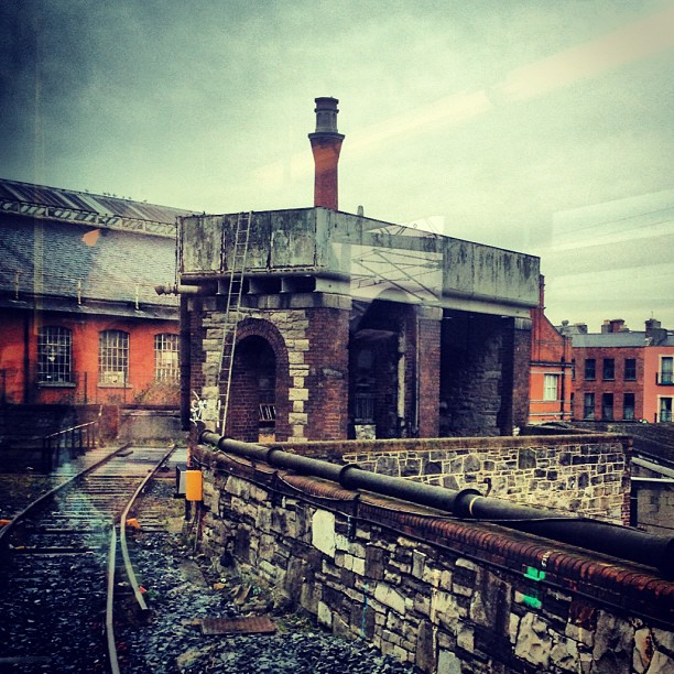 A small brick building next to a train track