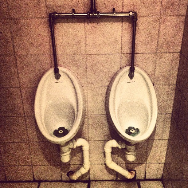 Two toilets on a wall