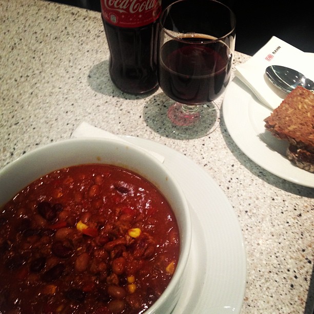 A bowl of chilli con carne and a bottle of Coca Cola