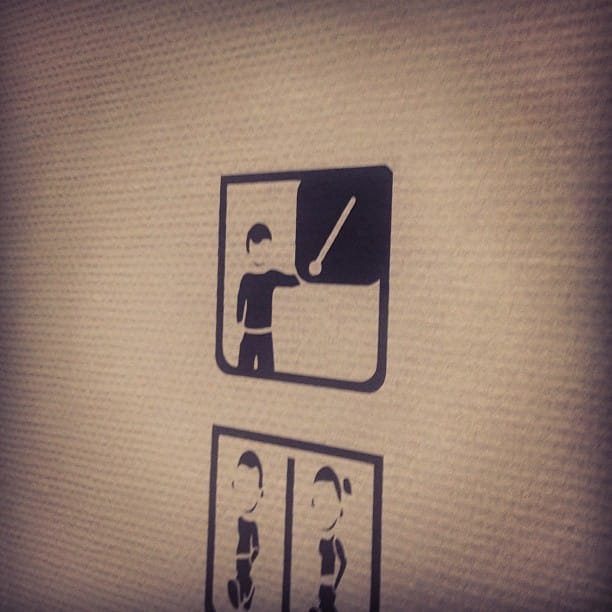 Pictogram on a wall with a person holding a stick (that looks like a lightsaber)