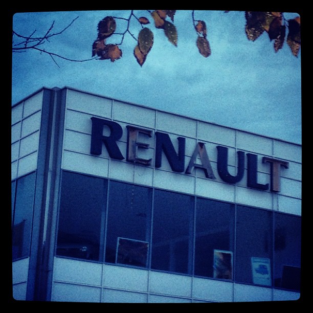 A partially disassembled Renault sign on a building