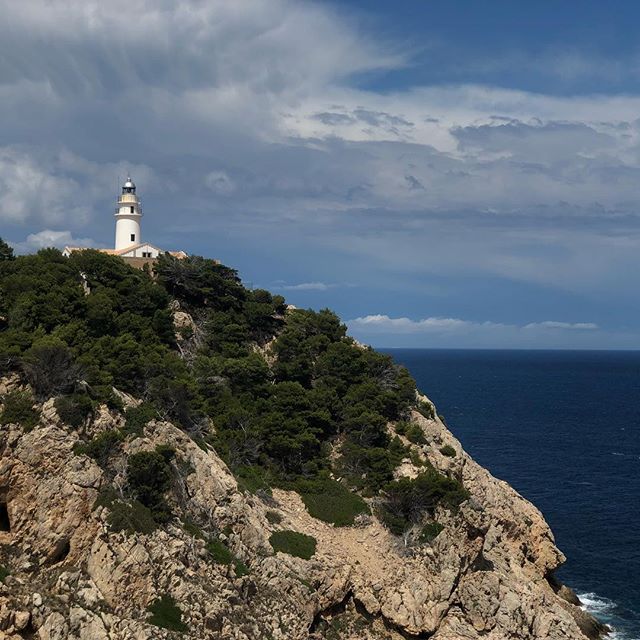 Lighthouse on a cliff ocean to the right of the cliff.