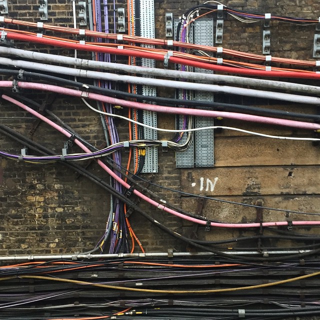 A wild assortment of colourful cables fixed on a wall