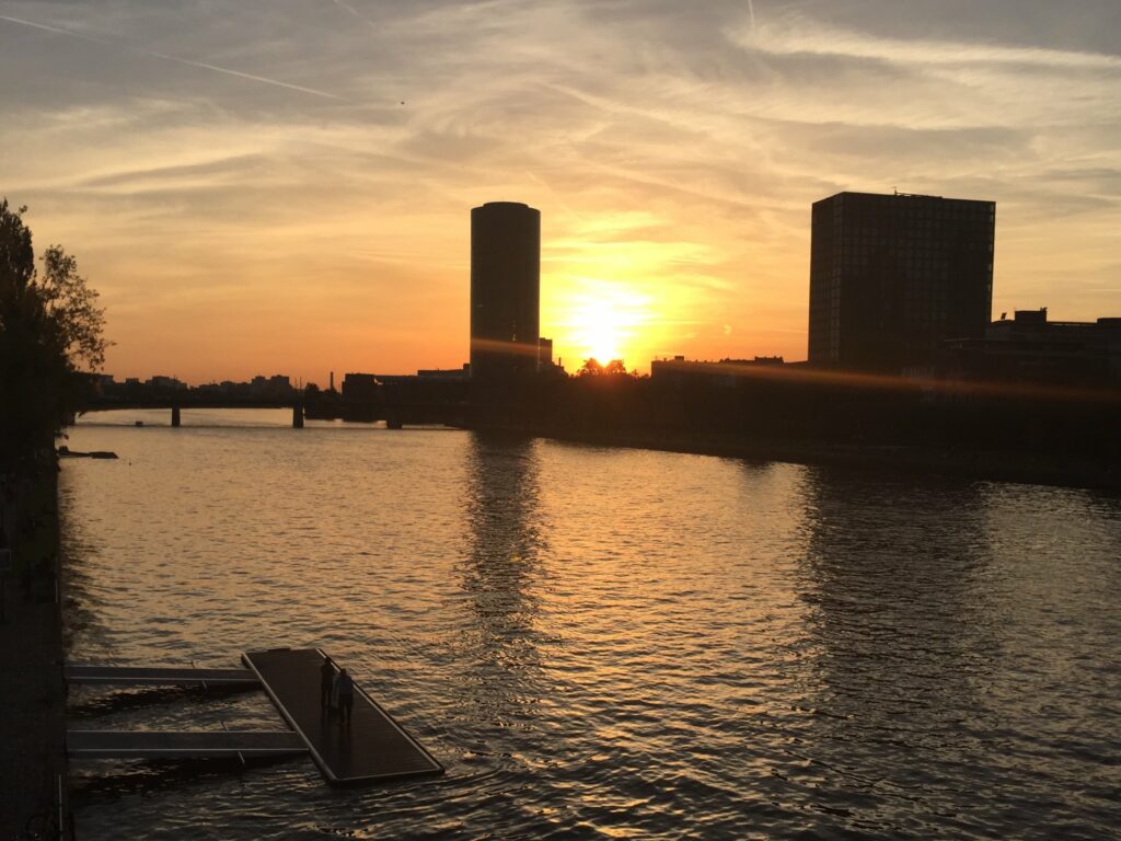 A river in the front and two buildings in the back