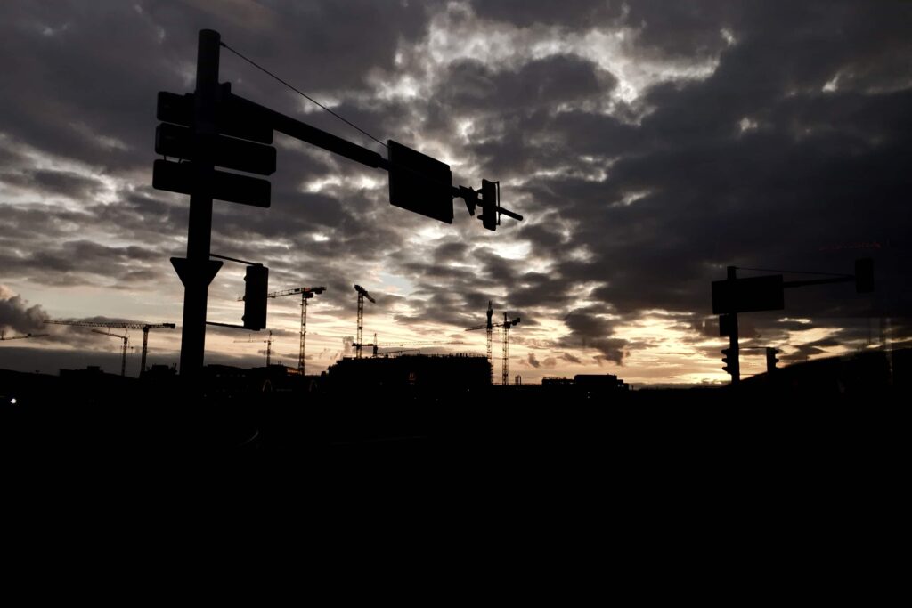 Light clouds at dawn, traffic lights and a building site in the distance