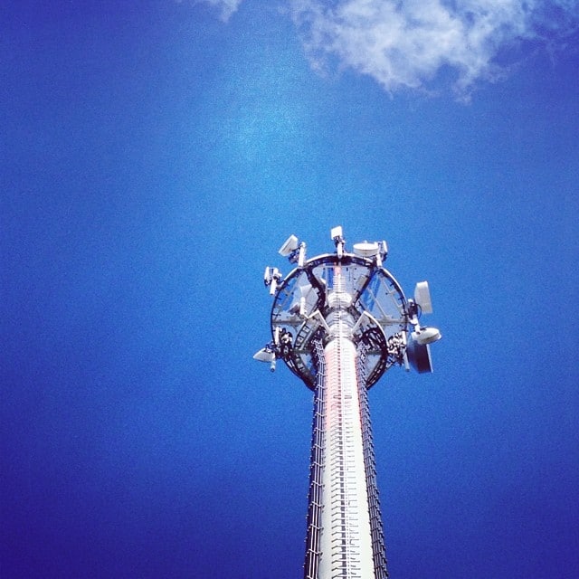 A communication tower with a dark blue sky as a backdrop