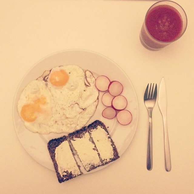 Fried eggs, some radish a bread and some tomato juice