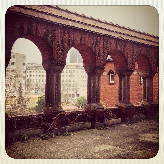 A red brick wall with arches and columns