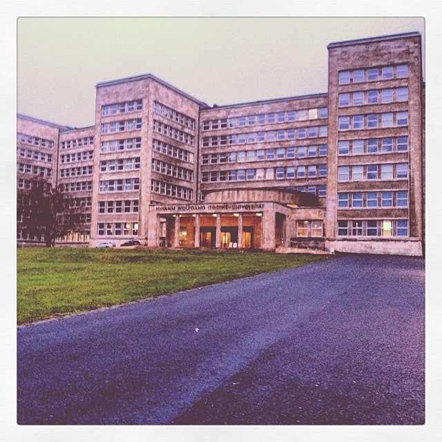 A brutalist building, with a sign over the entrance "Johann Wolfgang Goethe Universität"