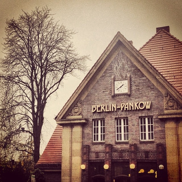 Brick building next to a tree without leafs. A sign on the building says "Berlin-Pankow"