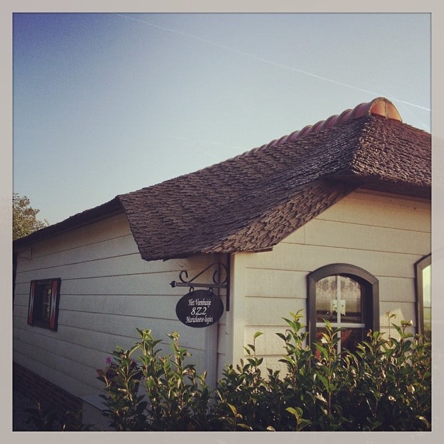 Small dutch building with white facade and straw roof