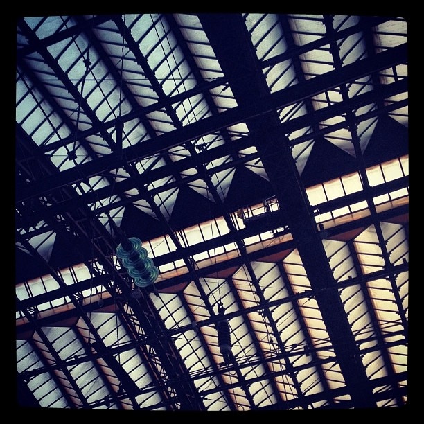 An old steel and glass roof over a train station