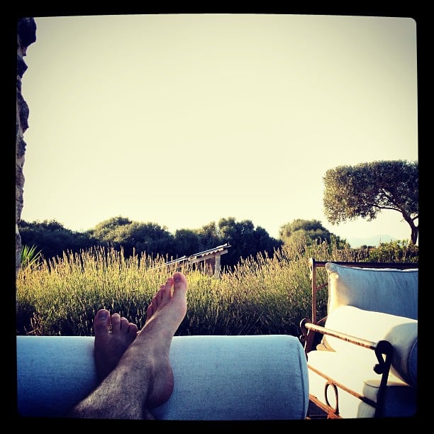 A persons feed on an outdoor sofa