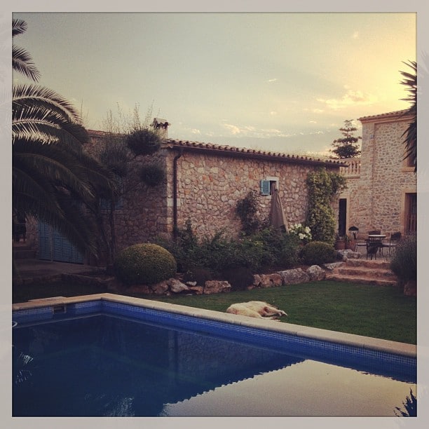 A small pool in the front, two stone building behind it