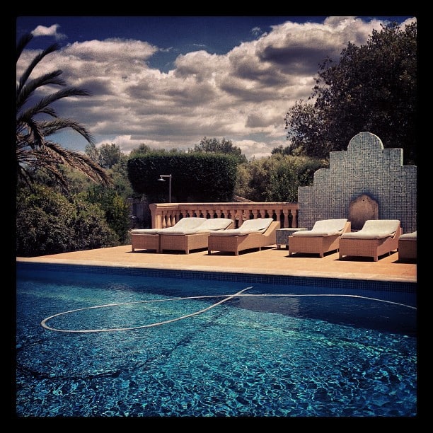 A pool with some son beds in the background