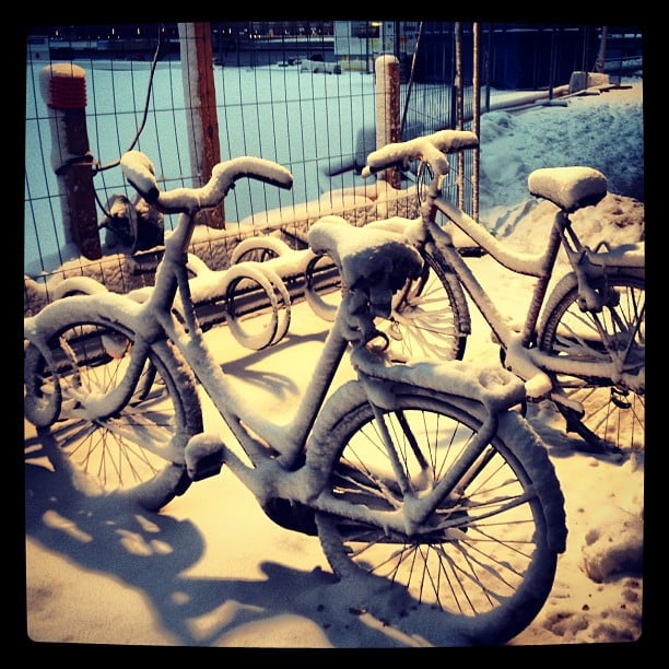 two parked bikes covered in snow