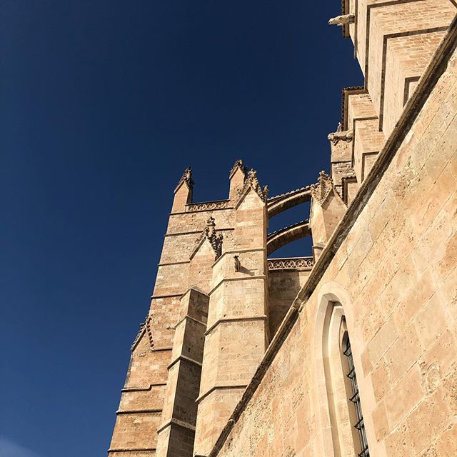 Side wall and part of a tower of the cathedral of Palma in front of a deep blue sky