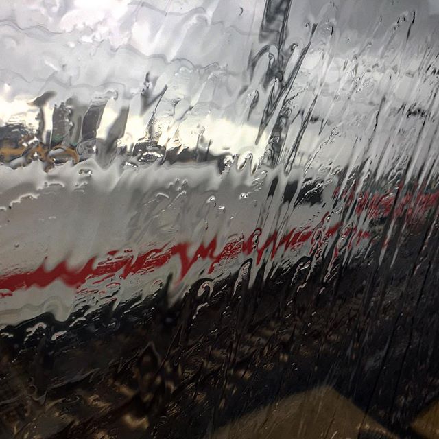 Photo through a window covered in rain. Out of focus outside: an ICE train