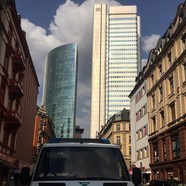 Two high-rises at the end of a residential road. Police car in the front