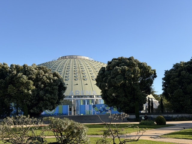 The super block arena in Porto, a round building between some trees in a park