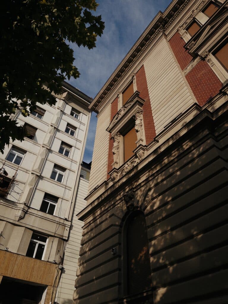 Photo of two buildings, looking up from street level.