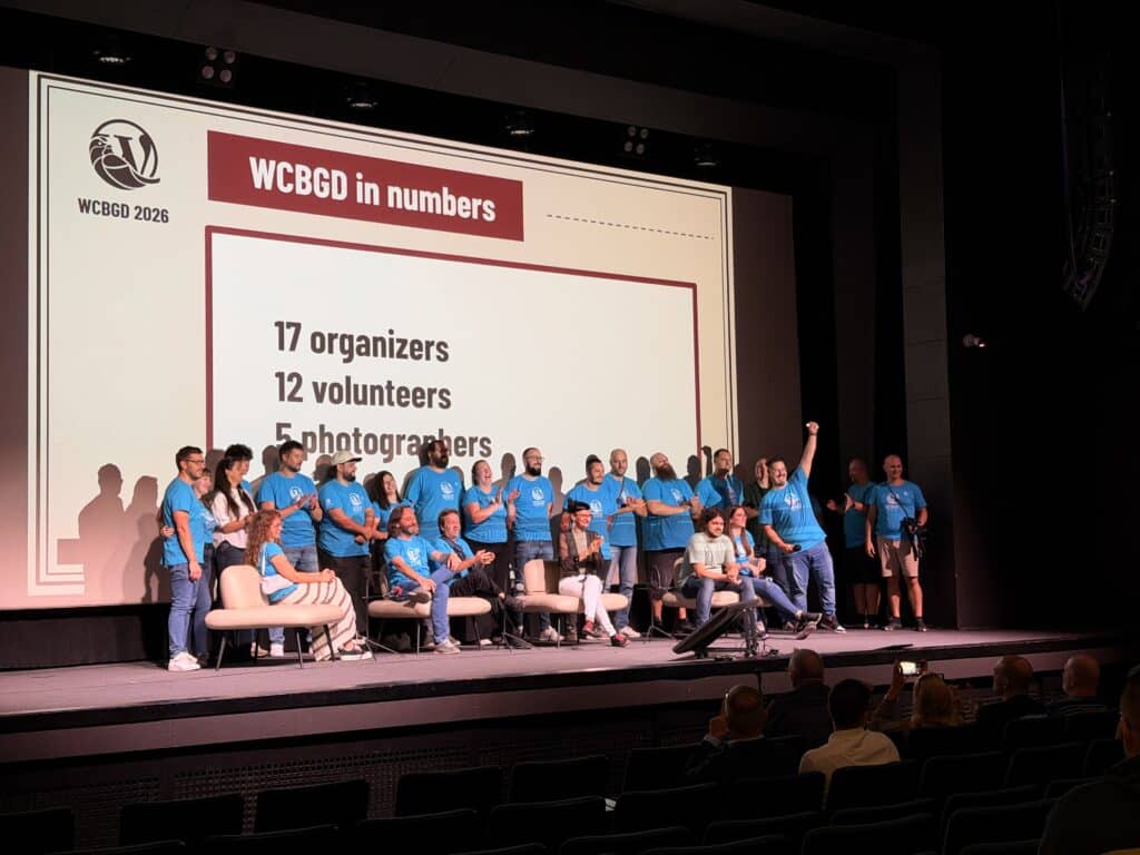 Organizers and volunteers in light blue shirts on stage.