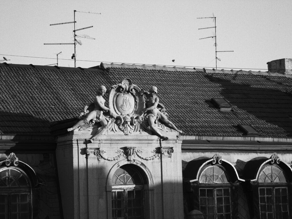 Blank and white photo of an old, ornate facade of a building.